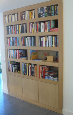 Boekenkast in nieuwe situatie. In overleg met de klant is goed nagedacht welke boeken, waar geplaatst moeten worden. Hieruit is de vakverdeling bepaald. De kast is gemaakt eikenhout. De deurtjes onderin zijn greeploos gemaakt met behulp van het Tip-on systeem van Blum.